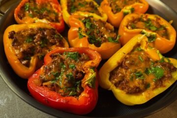 Sloppy Joe stuffed bell peppers filled with seasoned ground beef and melted cheddar cheese, topped with fresh parsley.