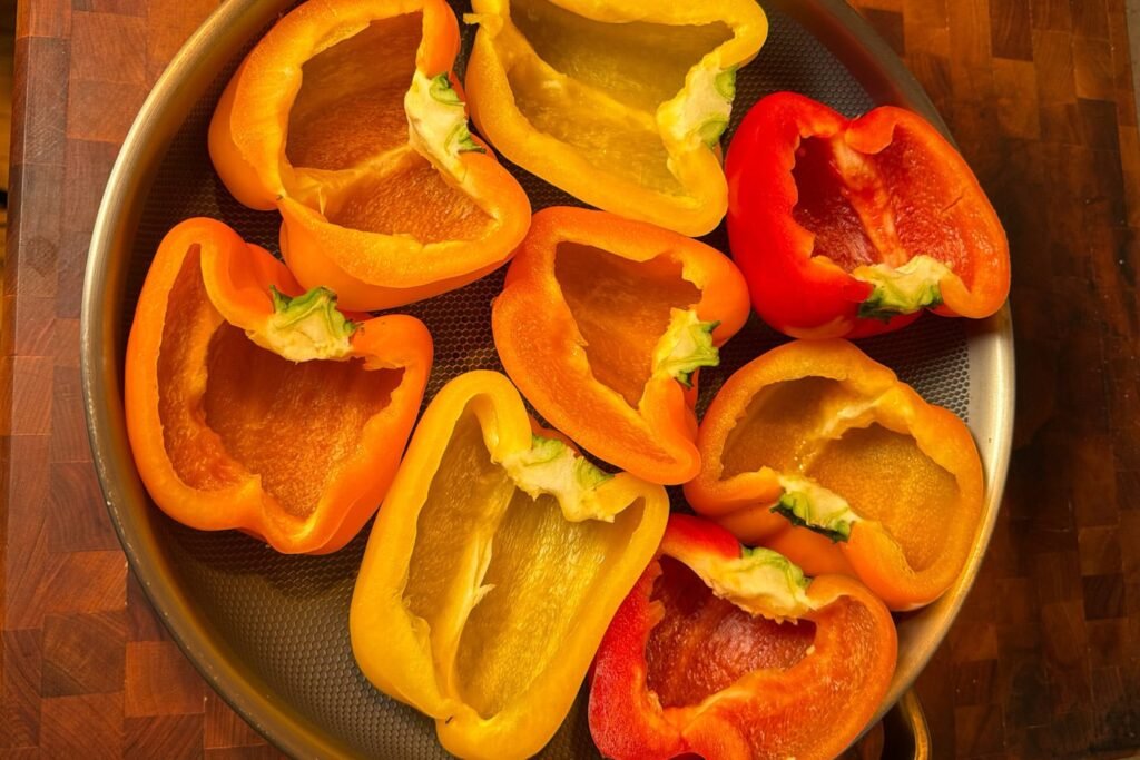 Bell pepper halves arranged cut side up in a baking pan for Sloppy Joe stuffed peppers